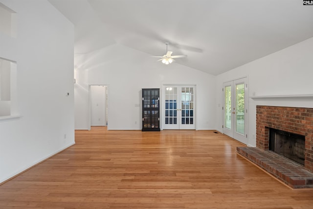 unfurnished living room with a ceiling fan, french doors, a brick fireplace, light wood-type flooring, and baseboards