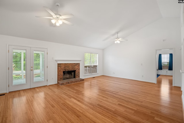 unfurnished living room featuring a healthy amount of sunlight, high vaulted ceiling, ceiling fan, and light wood finished floors