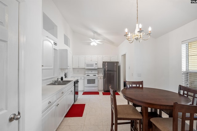 kitchen featuring a sink, light countertops, ceiling fan with notable chandelier, lofted ceiling, and white appliances