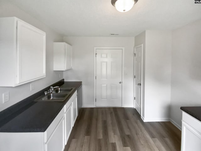6 Sawdust Ct, Columbia, SC 29209 - kitchen featuring dark wood-style flooring, dark countertops, baseboards, white cabinets, and a sink
