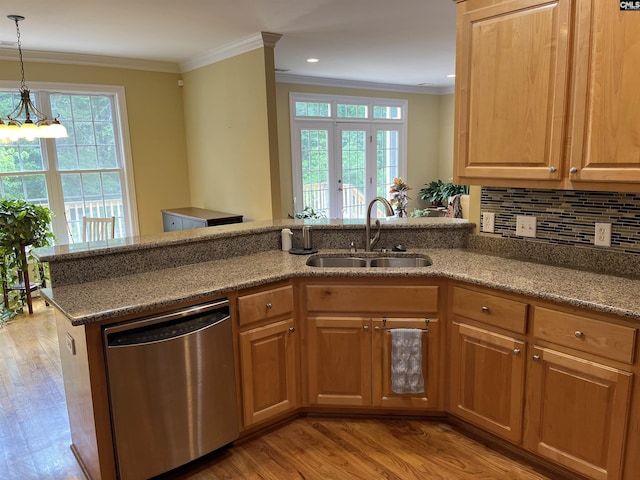kitchen with a sink, ornamental molding, light wood finished floors, and dishwasher