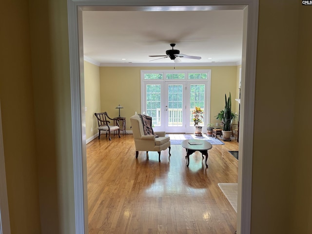 sitting room with baseboards, ornamental molding, ceiling fan, and wood finished floors