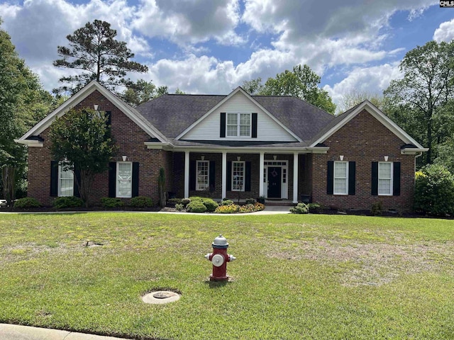 craftsman-style house with brick siding, a front lawn, and a porch
