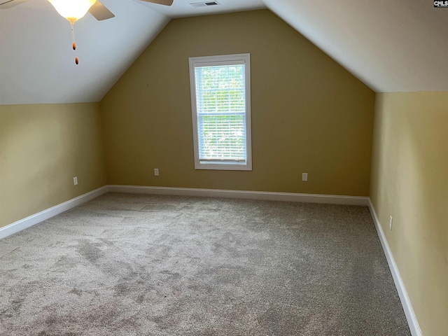 additional living space with visible vents, lofted ceiling, baseboards, ceiling fan, and carpet