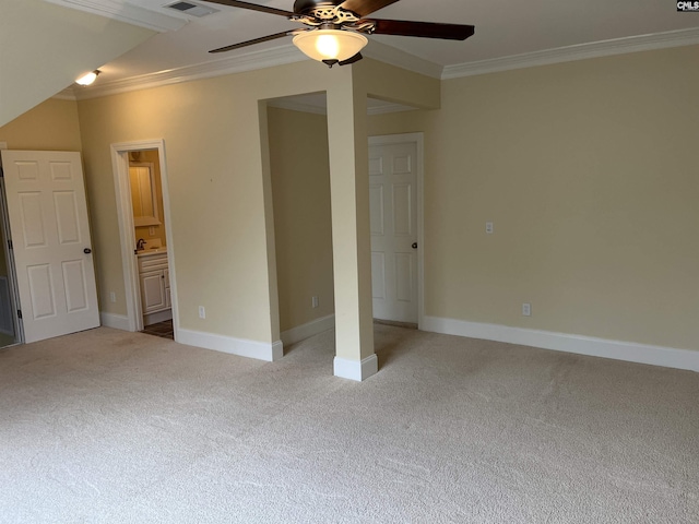 unfurnished bedroom featuring light carpet, ensuite bath, baseboards, visible vents, and ornamental molding