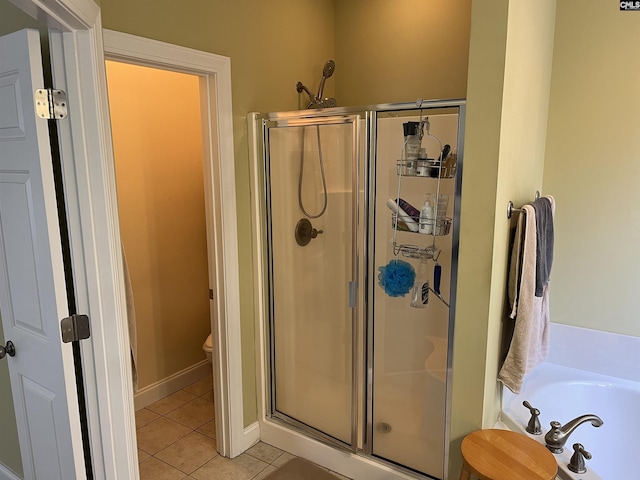 full bath featuring a garden tub, toilet, tile patterned flooring, and a stall shower