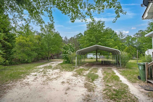 exterior space featuring dirt driveway and a detached carport