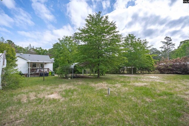 view of yard featuring a deck and a carport