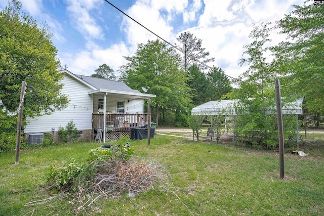 view of yard with central AC and a wooden deck
