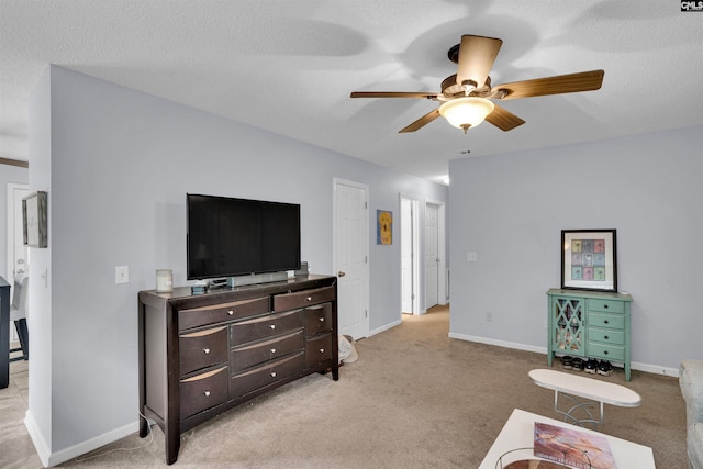interior space with baseboards, light carpet, a ceiling fan, and a textured ceiling