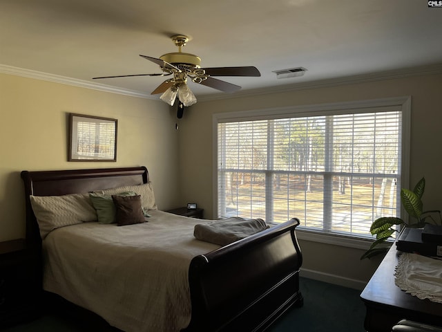 carpeted bedroom with visible vents, ornamental molding, baseboards, and ceiling fan