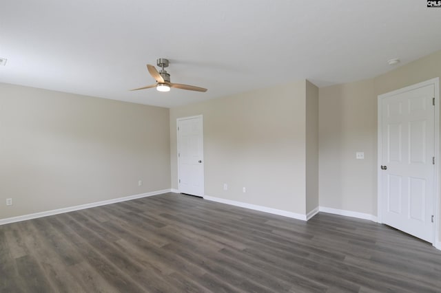 unfurnished room featuring baseboards, a ceiling fan, and dark wood finished floors