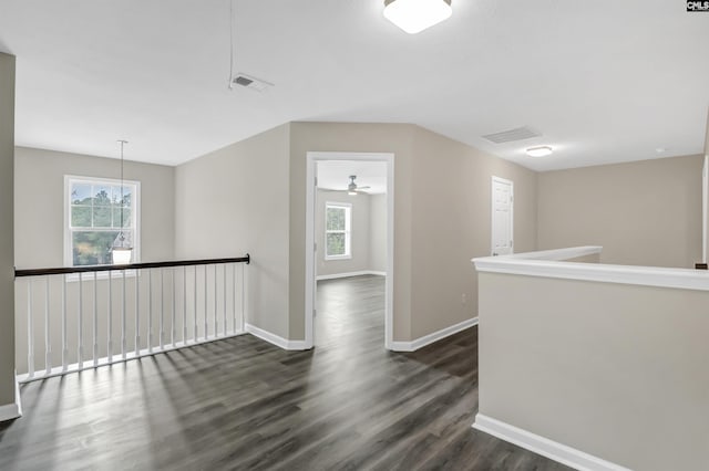 interior space featuring a healthy amount of sunlight, baseboards, dark wood-style flooring, and visible vents