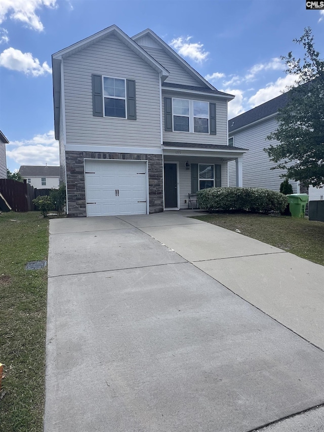 view of front facade with a garage, a front yard, driveway, and stone siding