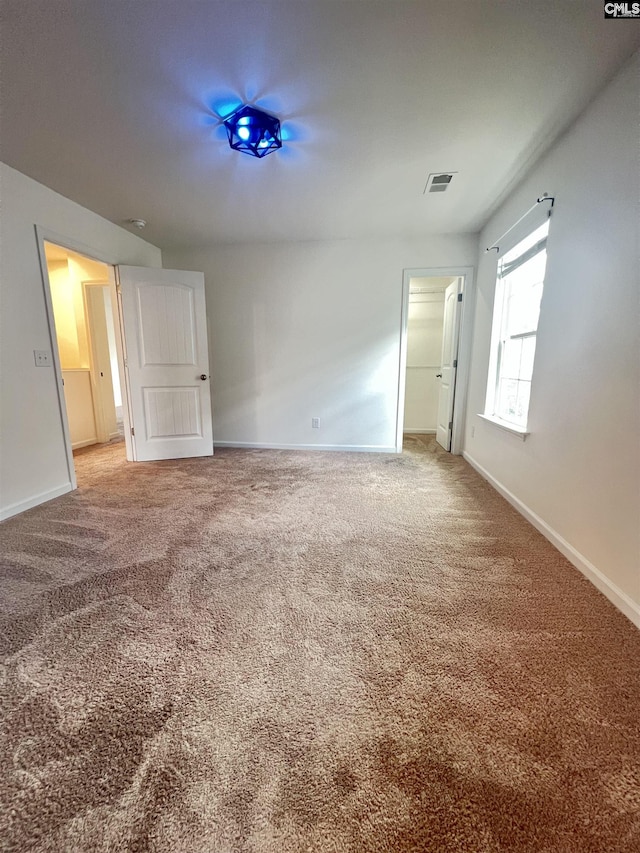 empty room featuring carpet flooring and baseboards