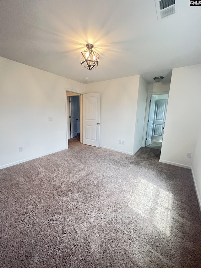 empty room featuring visible vents, carpet flooring, and baseboards