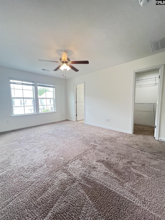 interior space with baseboards, visible vents, a spacious closet, and carpet