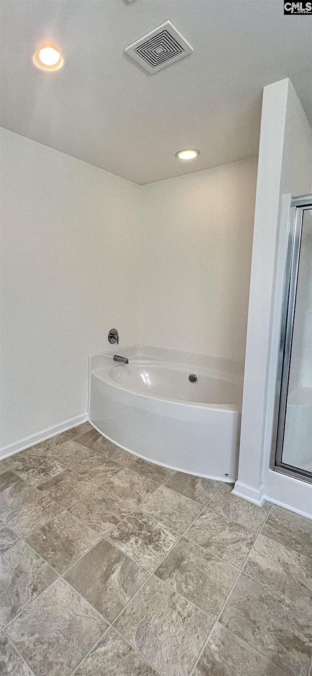 full bath with baseboards, visible vents, a garden tub, and a stall shower