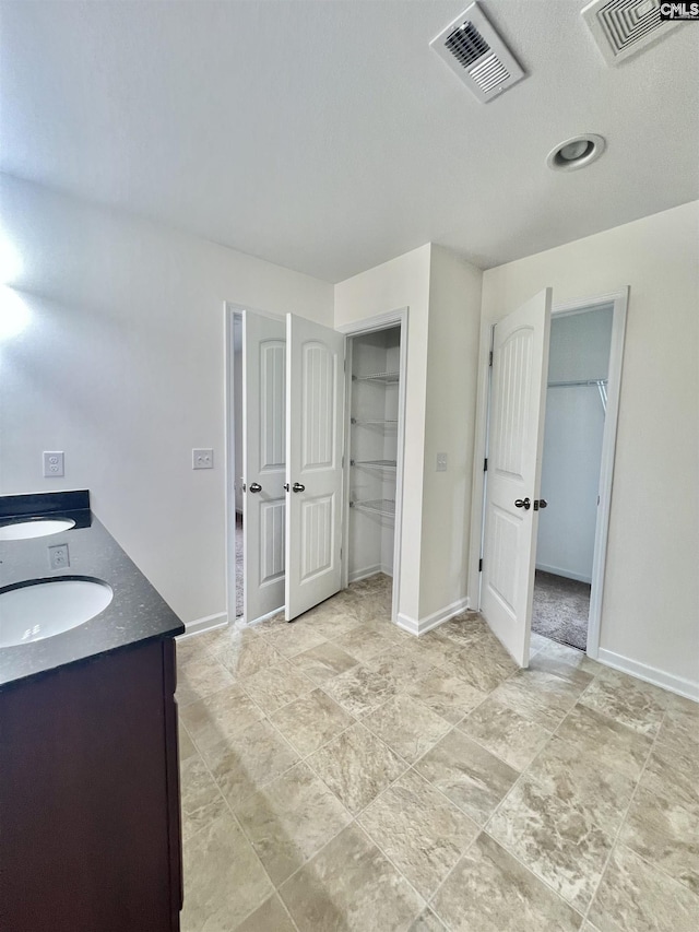 full bath featuring a sink, baseboards, and visible vents