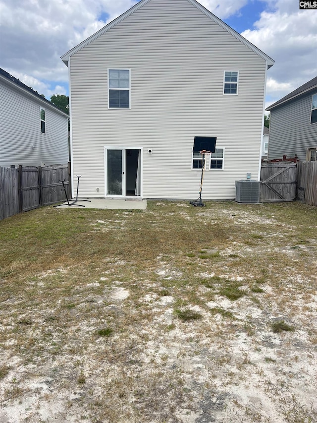 rear view of property featuring a fenced backyard, a lawn, and central AC