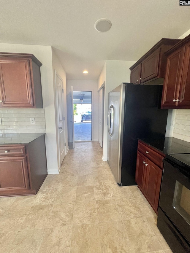kitchen featuring dark countertops, backsplash, and stove