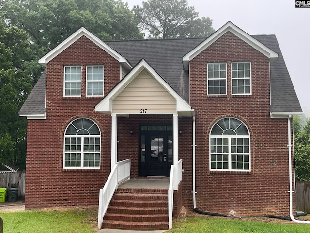 traditional home with brick siding and a shingled roof