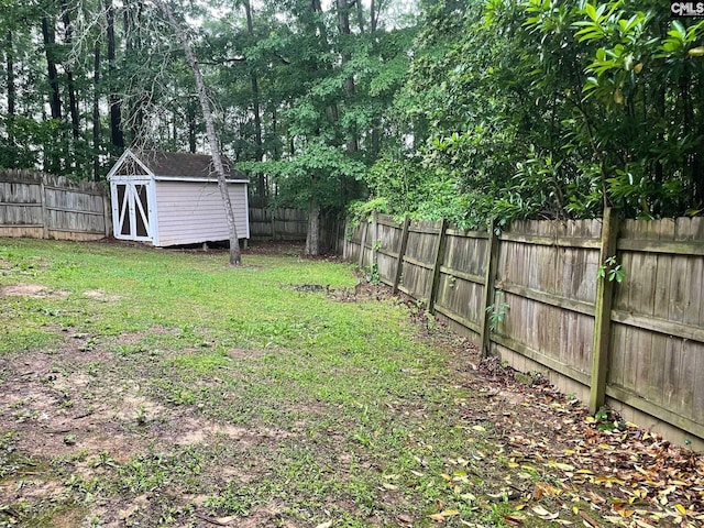view of yard featuring a fenced backyard, an outdoor structure, and a shed