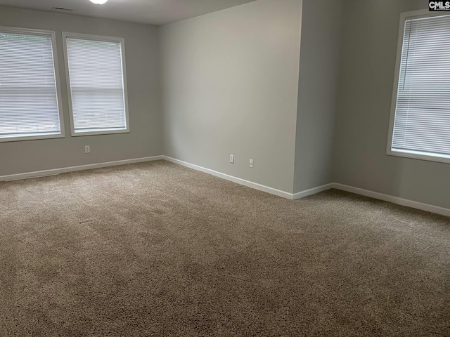 unfurnished room featuring baseboards and carpet