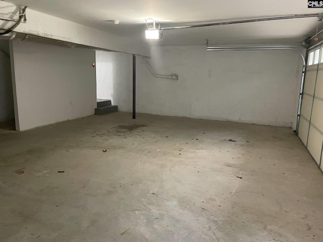 garage with concrete block wall and a garage door opener