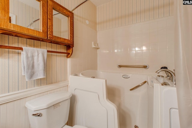 full bath with toilet, wallpapered walls, and wainscoting