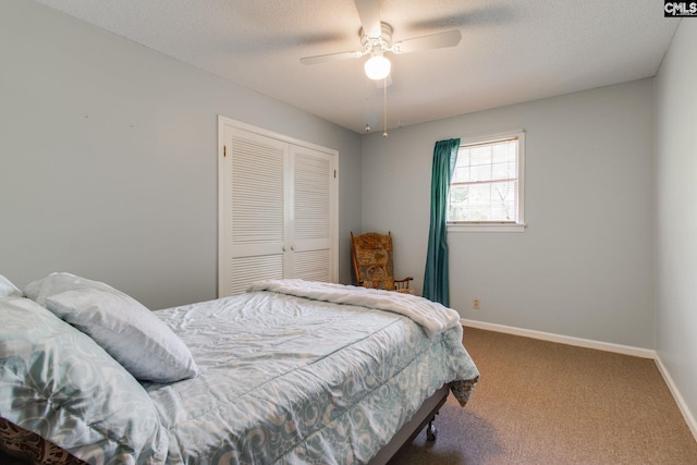 carpeted bedroom featuring a textured ceiling, baseboards, ceiling fan, and a closet