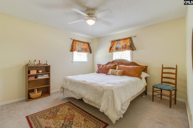 bedroom featuring baseboards, a ceiling fan, carpet, and a textured ceiling