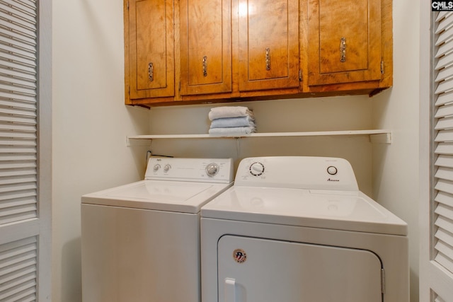 washroom featuring washing machine and dryer and cabinet space