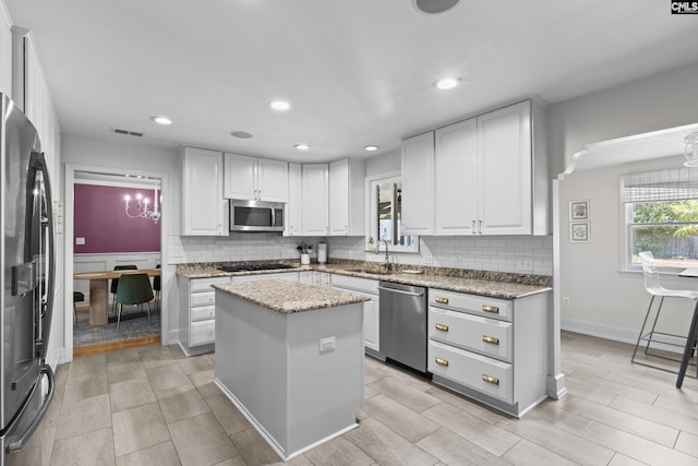 5904 Lakeshore Dr, Columbia, SC 29206 - kitchen featuring white cabinets, stainless steel appliances, a sink, and tasteful backsplash