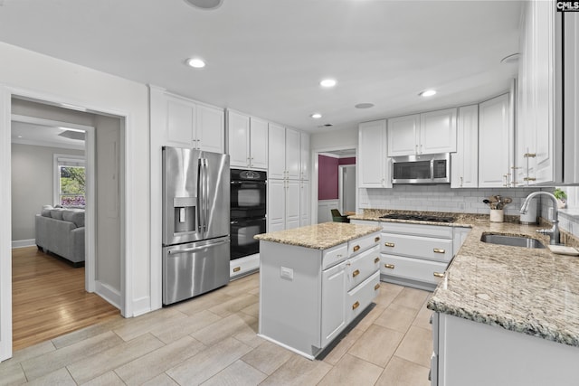 5904 Lakeshore Dr, Columbia, SC 29206 - kitchen featuring a center island, a sink, light stone counters, black appliances, and white cabinetry