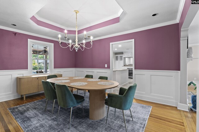 5904 Lakeshore Dr, Columbia, SC 29206 - dining space featuring a notable chandelier, wainscoting, a raised ceiling, a decorative wall, and light wood-type flooring