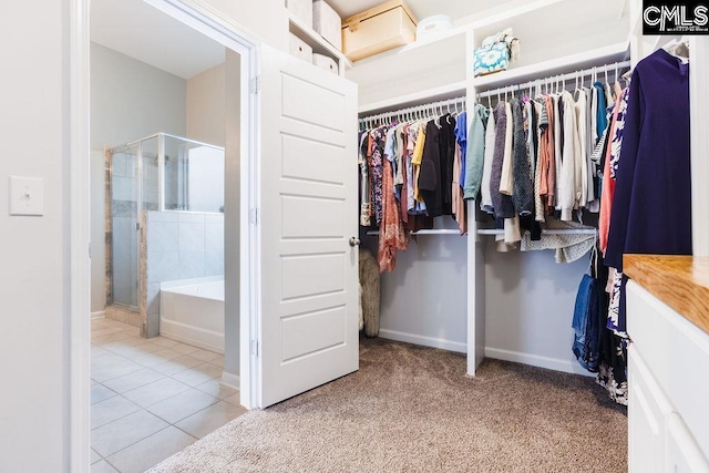 walk in closet featuring carpet floors and tile patterned flooring