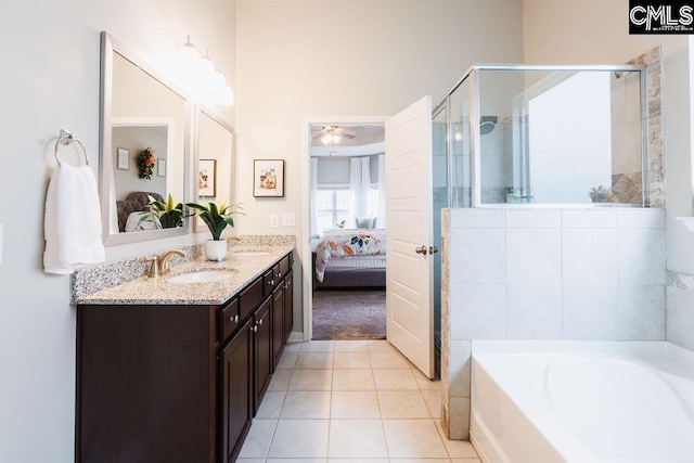 full bath with tile patterned flooring, a garden tub, a stall shower, a sink, and ensuite bath