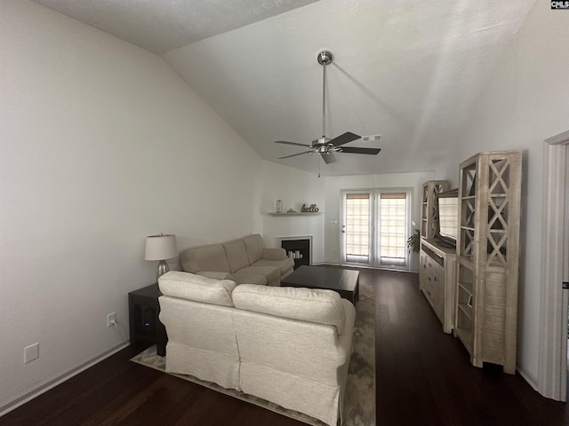 living area featuring ceiling fan, visible vents, a fireplace, vaulted ceiling, and dark wood-style floors