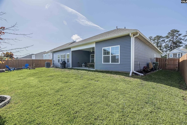 rear view of property with a lawn, central AC, a fenced backyard, and a patio area