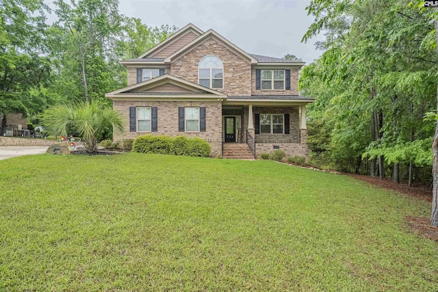 view of front of house featuring a porch, a front lawn, and brick siding