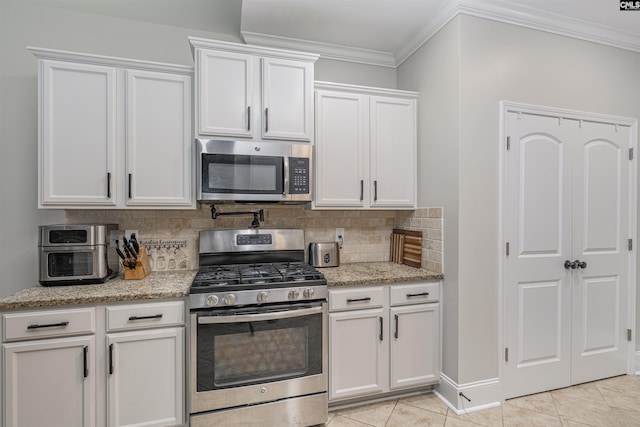 kitchen featuring tasteful backsplash, light stone countertops, ornamental molding, stainless steel appliances, and white cabinetry