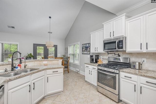 kitchen featuring white cabinets, appliances with stainless steel finishes, a sink, backsplash, and visible vents