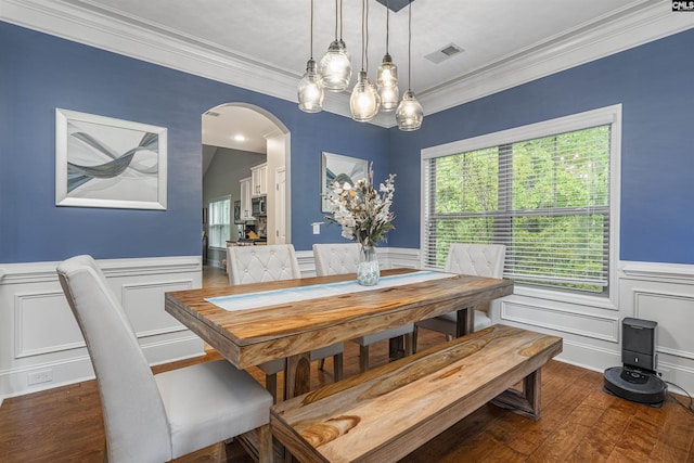 dining area with visible vents, arched walkways, crown molding, and hardwood / wood-style flooring