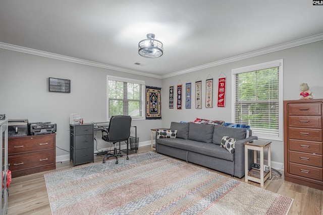 office area with crown molding, light wood-type flooring, and a healthy amount of sunlight