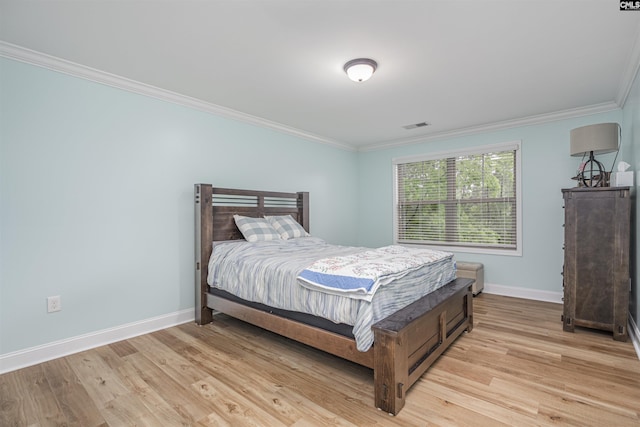 bedroom with crown molding, baseboards, visible vents, and light wood-type flooring