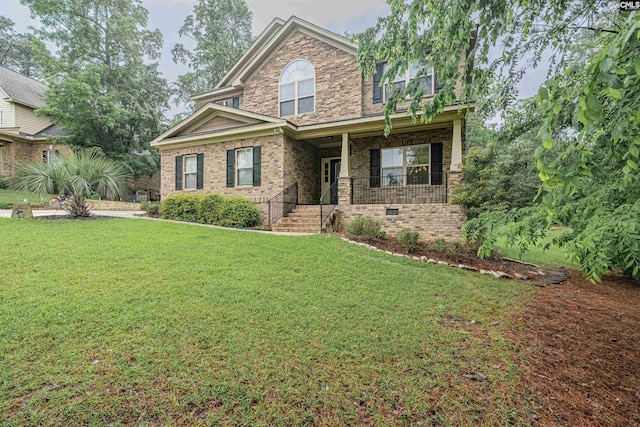 view of front of home with a porch, a front lawn, and brick siding