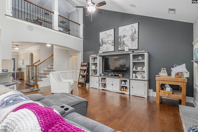 living room with arched walkways, ceiling fan, wood finished floors, and stairway