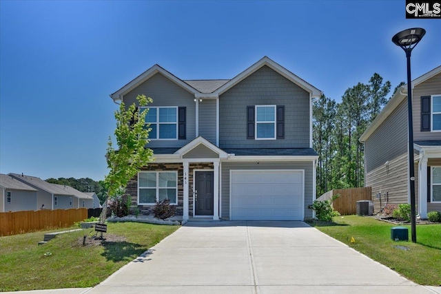 traditional-style home with fence, central AC unit, concrete driveway, and a front yard