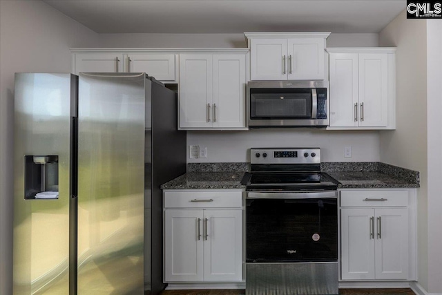 kitchen with dark stone countertops, white cabinets, and stainless steel appliances